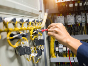 electricians-hands-testing-current-electric-in-control-panel