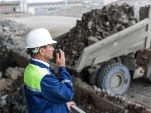 mining-engineer-uniform-supervises-unloading-dumpers
