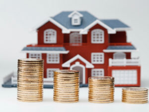 rmb-coins-stacked-in-front-of-the-housing-model-house-prices-house-buying-real-estate-mortgage-concept