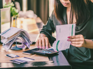 asian-woman-with-financial-bills-calculating-debt
