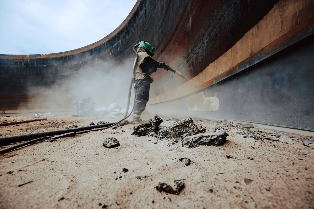 female-worker-surface-corrosion-plate-preparation-by-sand-blasting-tank-internal-oil