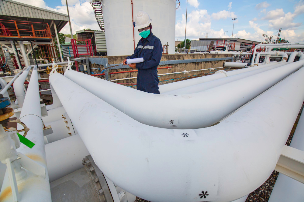 male-worker-inspection-steel-long-pipes-pipe-elbow-station-oil-factory-during-refinery-valve-visual-check-record-pipeline-oil-gas-industry
