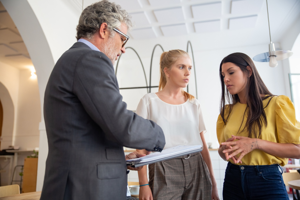 mature-loan-inspector-with-notepad-visiting-young-entrepreneurs-onsite