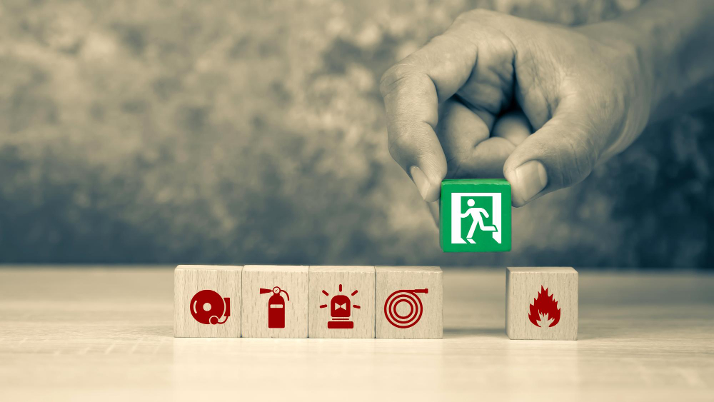 hand-choose-wooden-block-stack-with-door-exit-sing-or-fire-escape-and-fire-prevent-icon-with-fire-extinguisher-and-emergency-protection-symbol-for-safety-and-rescue-in-the-building