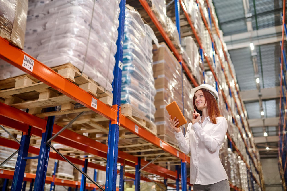 woman-with-tablet-working-near-warehouse-shelves-with-cargo